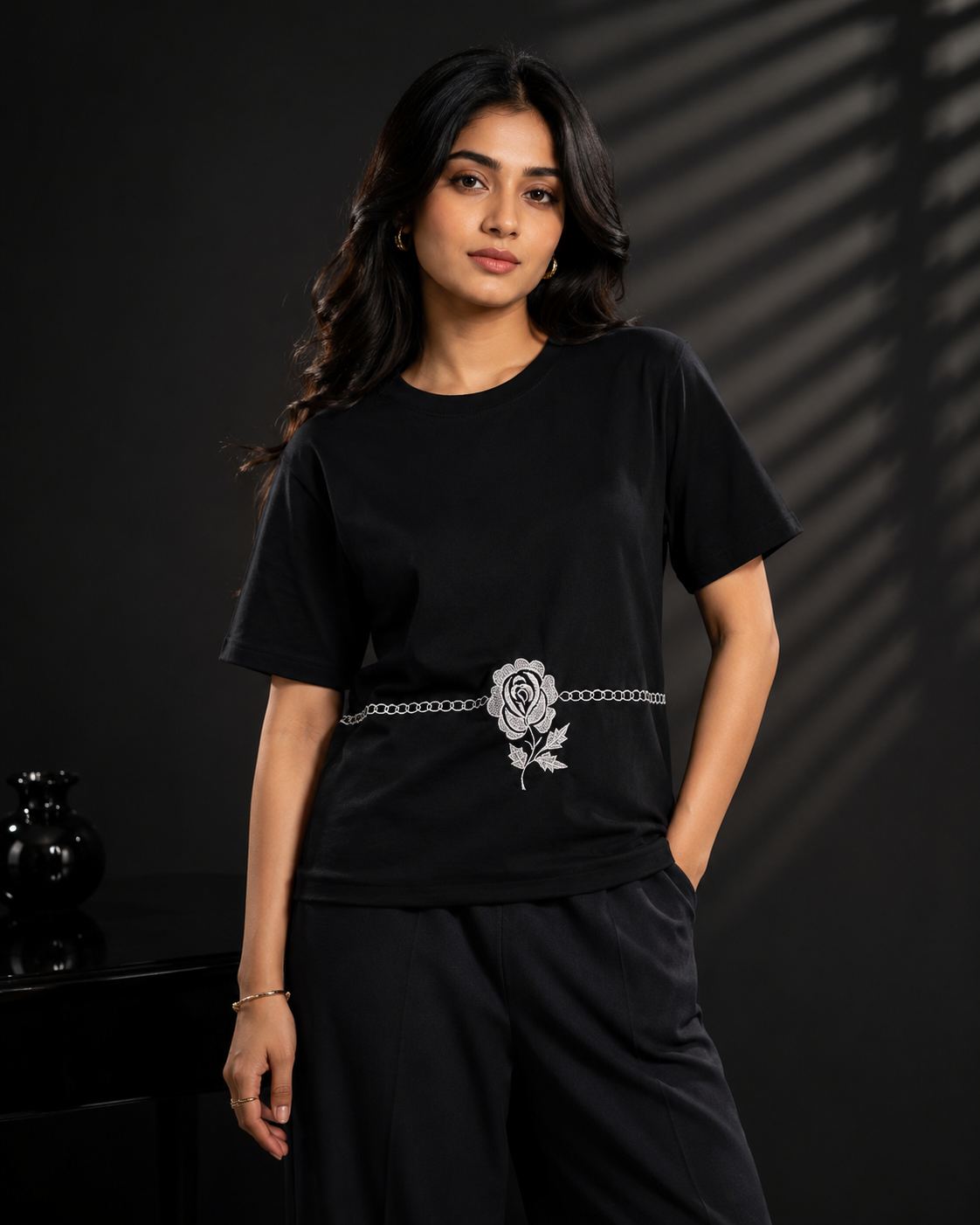 AI-generated editorial photoshoot for IZZ Habitus, black tee with rose belt against a striped-shadow backdrop