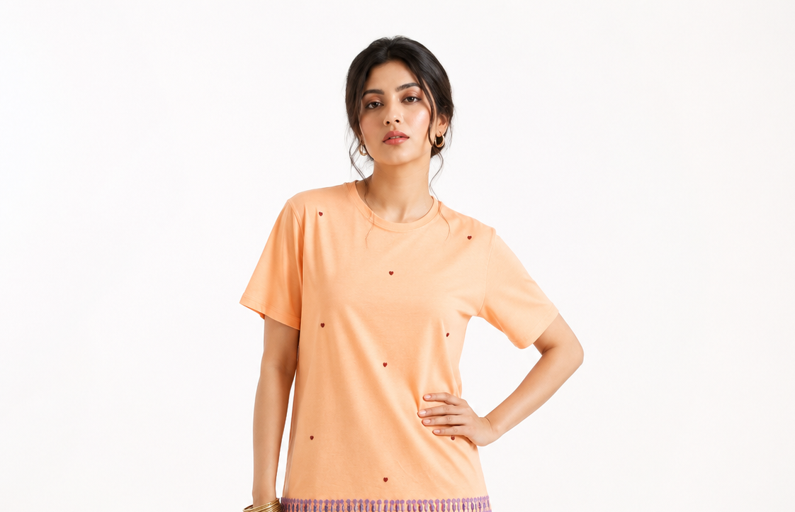 AI-generated product photoshoot for IZZ Habitus, peach tee with heart motifs and fringed hem trim